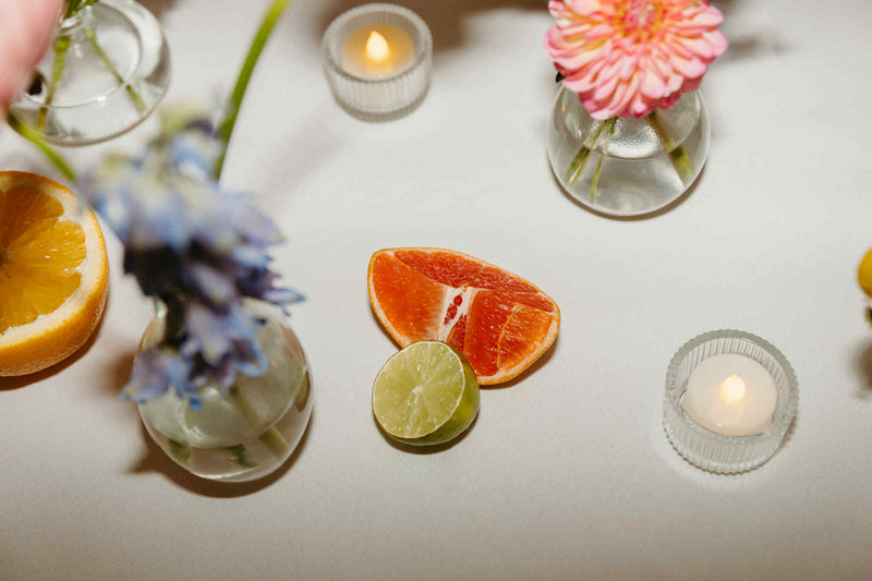 Fruits and flowers on a white surface with candles for wedding flowers in Moncton, New brunswick, by quality vendor for wedding.