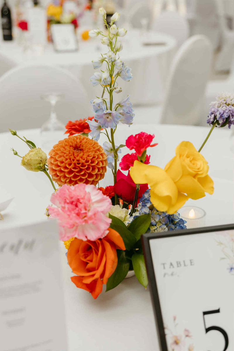 Colorful floral arrangement on a wedding table made by local florist in Moncton, Primavera Floral studio.